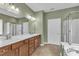 Bathroom featuring double sinks, a soaking tub, and a separate glass-enclosed shower at 113 Dowington Ln, Cary, NC 27519