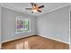 This bedroom features a ceiling fan, hardwood floors, and a window offering natural light at 113 Dowington Ln, Cary, NC 27519