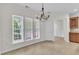 Bright dining area with large windows, a modern chandelier, and easy access to the kitchen at 113 Dowington Ln, Cary, NC 27519