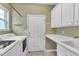 Bright laundry room with washer, dryer, sink, and white cabinets for storage at 113 Dowington Ln, Cary, NC 27519