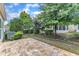 Backyard featuring a stone patio, mature trees, garden, and a well-maintained lawn at 113 Dowington Ln, Cary, NC 27519
