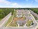 Wide aerial shot showcases a neighborhood filled with townhomes, manicured lawns, and tree-lined streets at 1136 Longitude Dr, Durham, NC 27713