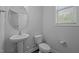 Powder room with a pedestal sink, toilet, and window providing natural light at 1136 Longitude Dr, Durham, NC 27713
