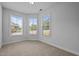 This bedroom features neutral carpet and three windows that let in plenty of natural light at 1136 Longitude Dr, Durham, NC 27713