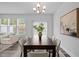 Dining room boasts a long table with seating for six, modern chandelier, and hardwood floors at 1136 Longitude Dr, Durham, NC 27713