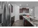 Modern kitchen features stainless steel appliances, granite countertops, and dark wood cabinets at 1136 Longitude Dr, Durham, NC 27713