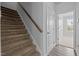 Carpeted staircase with wooden handrail leading to the upper level of the home at 1136 Longitude Dr, Durham, NC 27713