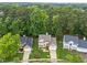 An aerial view shows houses with manicured lawns surrounded by trees and nature at 12325 Amoretto Way, Raleigh, NC 27613