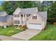 Aerial view of a two-story home with manicured lawn and mature trees at 12325 Amoretto Way, Raleigh, NC 27613