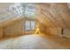 Unfinished attic space with a window, plywood flooring, and insulation at 12325 Amoretto Way, Raleigh, NC 27613