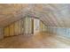 Plywood floor attic with insulation and doorway to other rooms at 12325 Amoretto Way, Raleigh, NC 27613