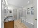 Bright bathroom featuring double sinks, a shower, and a tub at 12325 Amoretto Way, Raleigh, NC 27613