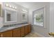 Bathroom with dual sinks, granite countertops, and natural light from a large window at 12325 Amoretto Way, Raleigh, NC 27613