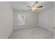 Bright bedroom featuring plush carpet, ceiling fan, and spacious closet at 12325 Amoretto Way, Raleigh, NC 27613