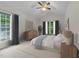 Tranquil main bedroom featuring natural light, ceiling fan, and serene décor at 12325 Amoretto Way, Raleigh, NC 27613