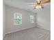 Carpeted bedroom with ceiling fan and two windows to provide ample natural light at 12325 Amoretto Way, Raleigh, NC 27613