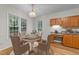 Cozy breakfast nook showcases sunlight, charming table setting, and oak cabinetry at 12325 Amoretto Way, Raleigh, NC 27613