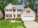 Two-story home with landscaped yard and two car garage on a sunny day at 12325 Amoretto Way, Raleigh, NC 27613