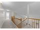 Second floor hallway has neutral carpet and classic wood railing, with a view of the living room at 12325 Amoretto Way, Raleigh, NC 27613