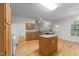 Bright kitchen featuring a central island, granite countertops, and wood floors at 12325 Amoretto Way, Raleigh, NC 27613