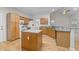 Spacious kitchen featuring granite counters, a kitchen island, and wood floors at 12325 Amoretto Way, Raleigh, NC 27613