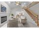 Bright living room features fireplace, stairway, vaulted ceilings and modern furnishings at 12325 Amoretto Way, Raleigh, NC 27613