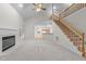 Bright living room featuring fireplace, carpet, ample windows, and staircase at 12325 Amoretto Way, Raleigh, NC 27613