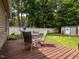 Backyard deck featuring an outdoor dining set, lush greenery, and a privacy fence at 1290 Pyrtle Dr, Graham, NC 27253