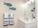 Clean bathroom with decorative fish art, towel racks, and vanity with a mirror at 1290 Pyrtle Dr, Graham, NC 27253