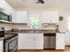 Well-equipped kitchen with stainless steel appliances, bright white cabinets, and a view of the backyard at 1290 Pyrtle Dr, Graham, NC 27253