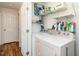 Functional laundry room with washer, dryer, storage shelves, and access to another room at 1290 Pyrtle Dr, Graham, NC 27253