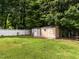 Outdoor storage shed featuring a door, window, and lush green lawn at 1290 Pyrtle Dr, Graham, NC 27253