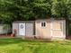 Backyard featuring two storage sheds, a swing, and a well-maintained lawn at 1290 Pyrtle Dr, Graham, NC 27253