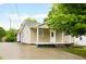 Charming home exterior with a covered front porch, clean lines, and ample parking on the paved driveway at 1309 Jackson St, Burlington, NC 27217