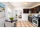 Kitchen with stainless steel appliances, dark cabinets, tiled floors and round table with two chairs at 1309 Jackson St, Burlington, NC 27217