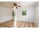 Bright living room featuring a ceiling fan, tiled floors and a front door leading to a porch at 1309 Jackson St, Burlington, NC 27217