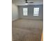 Spacious bedroom with plush carpet, two windows, and modern ceiling fan at 132 Rockfall Way, Rocky Mount, NC 27803