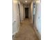 Neutral colored hallway with carpeted flooring and doors leading to various rooms at 132 Rockfall Way, Rocky Mount, NC 27803