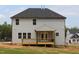 Exterior shot of a home with a wooden deck and steps leading to the expansive backyard at 1406 Reading Ct # 93 Kl, Burlington, NC 27217
