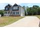 Two-story home boasts a long driveway, attached garage, and stylish gray siding at 1406 Reading Ct # 93 Kl, Burlington, NC 27217