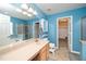 Bright bathroom with blue walls, a tub, a glass shower, a toilet, and a sink at 149 Cinder Cross Way, Garner, NC 27529