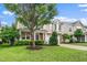 Two-story home featuring manicured lawn, stone accents, and a large tree in the front yard at 149 Cinder Cross Way, Garner, NC 27529