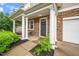 Welcoming front porch features stone accents, white columns, and manicured landscaping at 149 Cinder Cross Way, Garner, NC 27529
