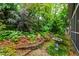 Tranquil backyard garden featuring a birdbath and colorful plants bordering the home at 1513 Dellwood Dr, Raleigh, NC 27607