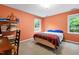 Bedroom showcases an orange painted wall with natural light and a view to outdoors at 1513 Dellwood Dr, Raleigh, NC 27607