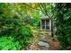 Secluded exterior view with stone pathway leading to a screened-in porch and beautiful landscaping at 1513 Dellwood Dr, Raleigh, NC 27607