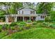 Charming two-story home with a landscaped front yard featuring lush greenery, flowerbeds, and a welcoming front porch at 1513 Dellwood Dr, Raleigh, NC 27607