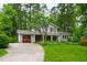 Inviting exterior showcasing a well-manicured lawn, a quaint home design, and a private driveway leading to a wooden garage at 1513 Dellwood Dr, Raleigh, NC 27607