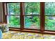 Cozy window seat with a patterned cushion, surrounded by large windows with garden views at 1513 Dellwood Dr, Raleigh, NC 27607
