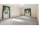 A bright, sunlit bedroom with dual windows and neutral carpet flooring at 1601 Castalia Dr, Cary, NC 27513
